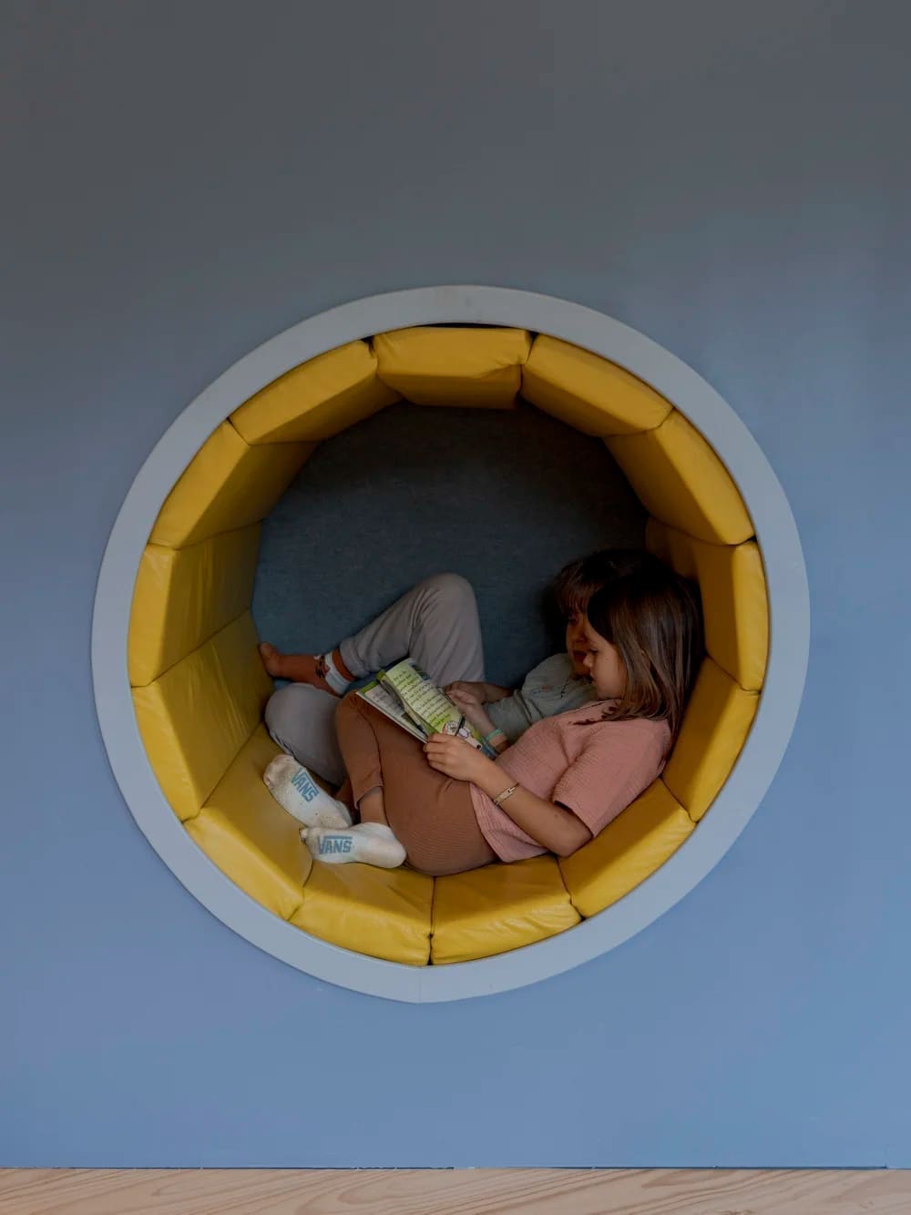 Early Years - A child reading in a cozy circular reading nook